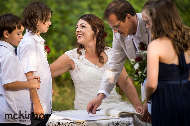 couple with children signing the marriage register